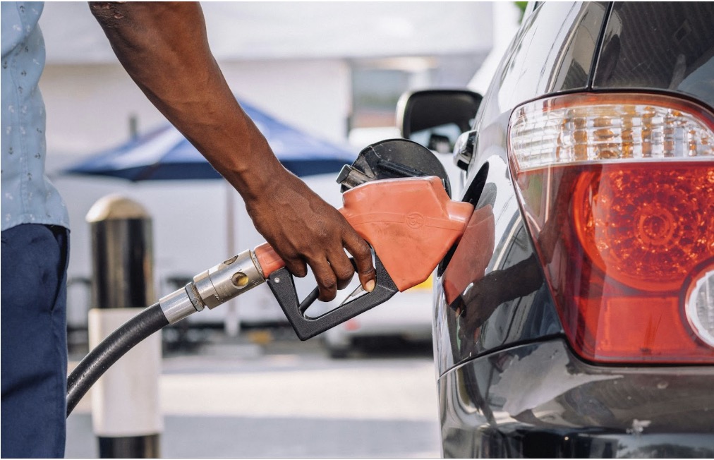 Person's hand using a fuel nozzle to gas up their car